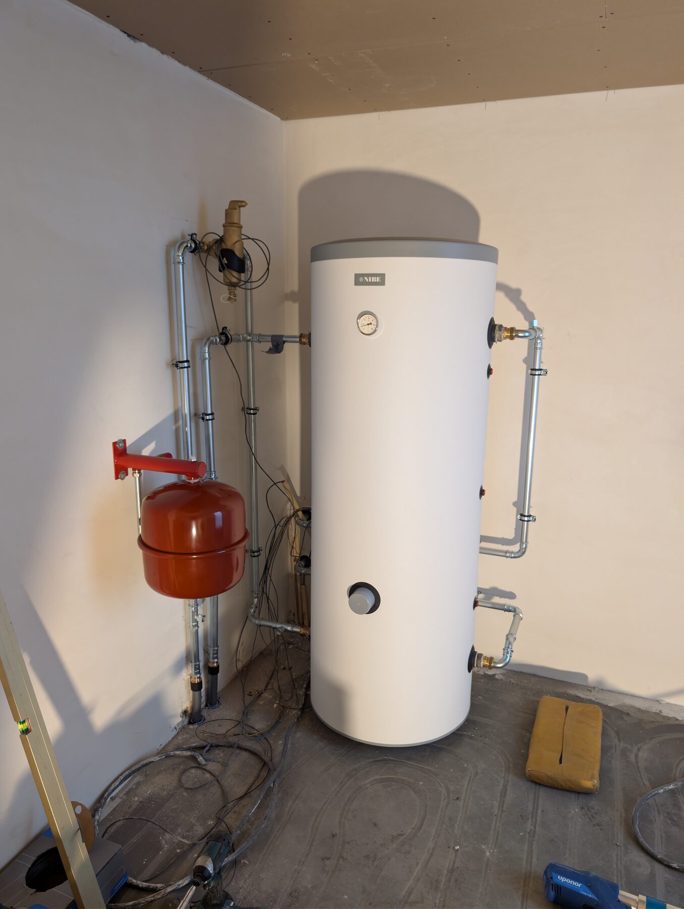Boiler met expansievat en leidingwerk aangesloten in een technische ruimte